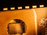 Ein EPROM (Erasable Programmable Read-Only Memory) ist ein nichtflüchtiger Speicherbaustein, der ab den 1970er Jahren in Computern eingesetzt wurde. Das gespeicherte Programm kann durch ultraviolettes Licht (Wellenlänge ca. 253,7 nm) wieder gelöscht werden. Deshalb besitzt der EPROM-Chip ein lichtdurchlässiges Quarzfenster, durch das ich hier fotografiert habe. Nach mehrminütiger UV-Bestrahlung ist der Speicher vollständig gelöscht und kann neu programmiert werden. Heute wird diese Technik nicht mehr benutzt. 